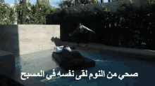 a man is floating in a pool with arabic writing on the bottom