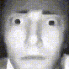 a black and white photo of a person 's face with a very serious look on their face .
