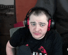 a man wearing headphones and a black shirt that says feed