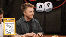 a man sitting at a table with a card that says 2 presses challenge