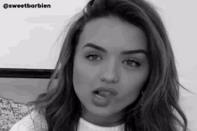 a black and white photo of a woman sticking out her tongue .