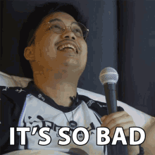 a man holding a microphone with the words " it 's so bad " on the bottom
