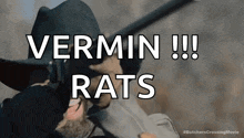 a man in a cowboy hat is holding a gun and saying `` vermin !! rats '' .