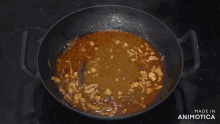 a person is covering a pan with a wooden lid and the words made in animotica are visible in the corner