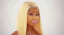 a woman with blonde hair and pink lips is wearing a pink lipstick .