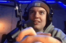 a man wearing headphones and a beanie is playing a video game .