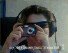 a woman wearing headphones is taking a picture of herself with a camera