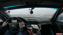 a man wearing a helmet is driving a bmw on a race track