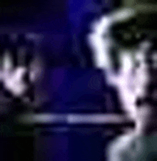 a blurry picture of a person 's face in a dark room with a blue background .