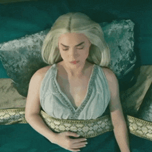 a woman in a white dress is laying on a bed