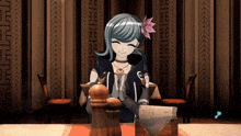 a girl with a flower in her hair sitting at a table