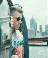 a man wearing sunglasses looks out of a window
