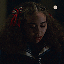 a girl with a red bow in her hair is smiling