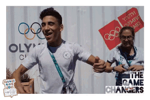 a man stands in front of a youth olympics sign