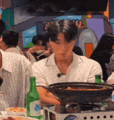 a man sitting at a table with a green bottle of water