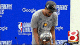 a man holding a trophy in front of a wall that says conference