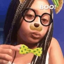 a girl wearing glasses and a bow tie with the word boo on her face