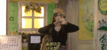 a woman is taking a picture of herself in front of a window in a room with korean writing on the wall