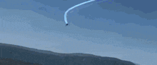 a red robot is flying over a mountain range