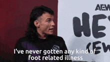 a man with a mullet is standing in front of a sign that says aew