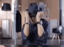 a man wearing a hat and sunglasses is sitting at a table .