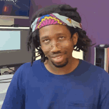 a man wearing glasses and a headband looks at the camera
