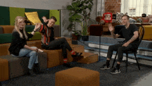 three people are sitting on a couch and one of them has a tattoo on his arm that says ' exxx '
