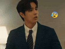 a man in a suit and tie with a sad face