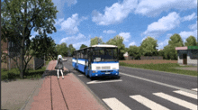 a blue and white bus drives down a street