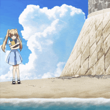 a girl in a blue dress is standing on the beach