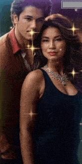a man and a woman are standing next to each other and the woman is wearing a necklace