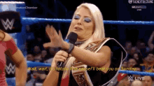 a woman is holding a microphone in a wrestling ring while talking into it .
