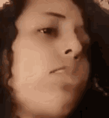 a close up of a woman 's face with a slight smile on her face .