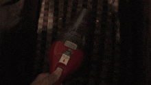 a person is holding a red vacuum cleaner with a white label that says ' i ' on it