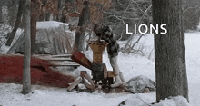 a man is using a wood chipper in the snow with the word lions above him .