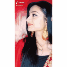 a close up of a woman wearing earrings and a red dress