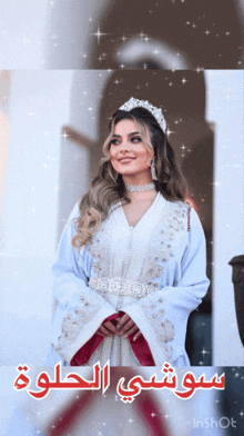 a woman wearing a white dress and a tiara with arabic writing