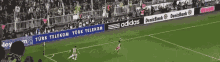 a soccer game is being played on a field with ads for adidas and turk telekom