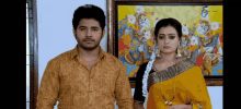 a man and a woman standing next to each other in front of a painting .