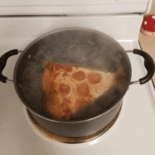 a slice of pepperoni pizza is cooking in a pot of boiling water