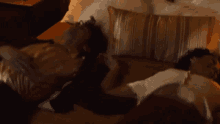 a couple laying on a bed with striped pillows