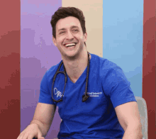 a smiling man wearing a blue scrub top with the name michael on the front