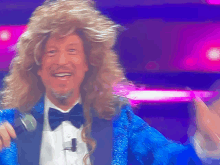a man wearing a wig and a bow tie is holding a microphone