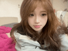 a young woman with long brown hair is laying on a bed