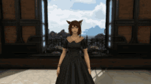 a woman in a black dress with a cat ear stands in front of a window