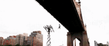 a person is doing a trick under a bridge in a city .