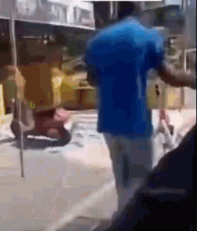 a blurry picture of a man in a blue shirt standing on a street