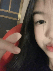 a close up of a girl 's face with a finger pointing to her nose