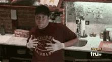 a man wearing gloves is standing in a kitchen with a tru tv sign on the counter