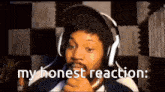 a man wearing headphones says " my honest reaction " in a video